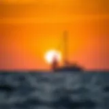 A serene sunset over the ocean with a sailboat silhouetted against the horizon