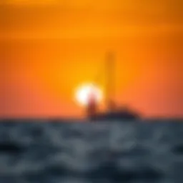 A serene sunset over the ocean with a sailboat silhouetted against the horizon