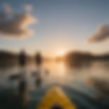 A serene sunrise over the water with paddleboarders in the distance.