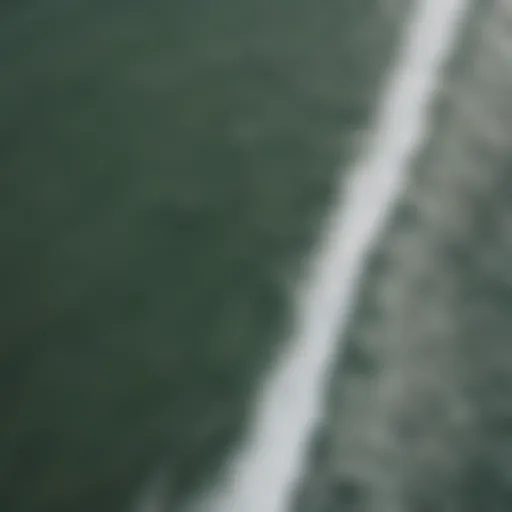 Aerial view of California coast with surfers riding waves