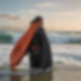 A surfer in a vibrant surf changing robe by the ocean.