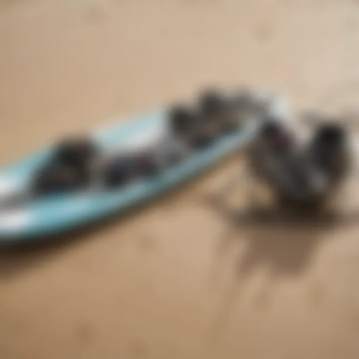 Close-up of wakeboard gear and surfboard equipment laid out on a sandy beach