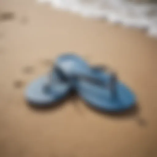 A pair of surf flip flops resting on a sandy beach